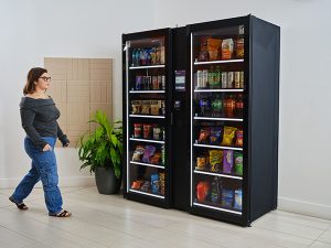 A woman walks up to a Smart Store in an office building.