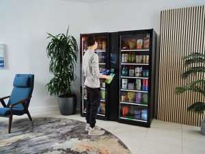 Young man browses household goods at a Smart Store in an apartment building
